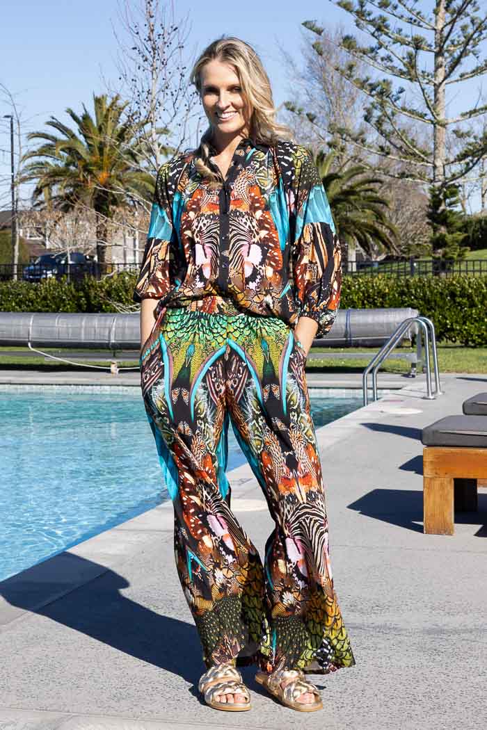 colorful, patterned wide-leg trousers with abstract print with turquoise, green, orange, black, and white.