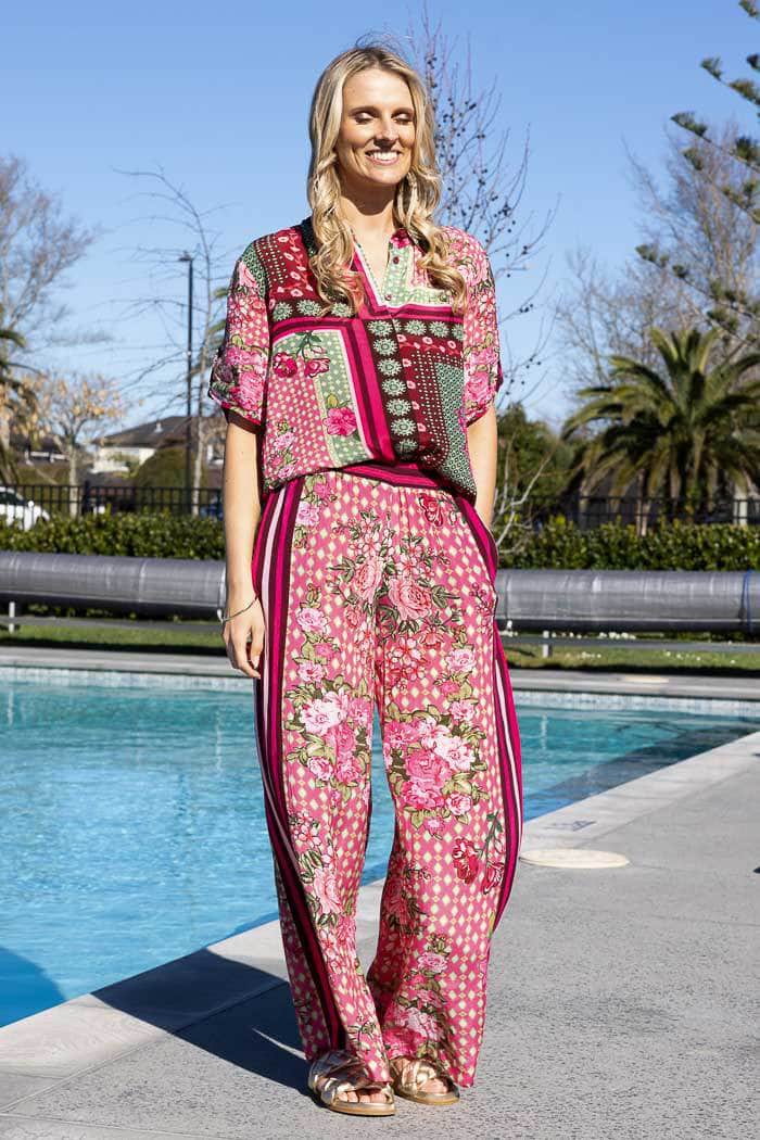 pink and green floral pant with red striped borders