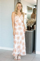 sleeveless white maxi dress with a large peach and orange floral pattern