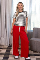 bright red wide-leg sweatpants featuring a white side stripe and white drawstring