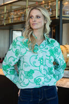 green long-sleeve button-up shirt with a green floral embroidery