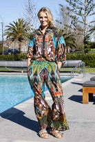 colorful, patterned wide-leg trousers with abstract print with turquoise, green, orange, black, and white.
