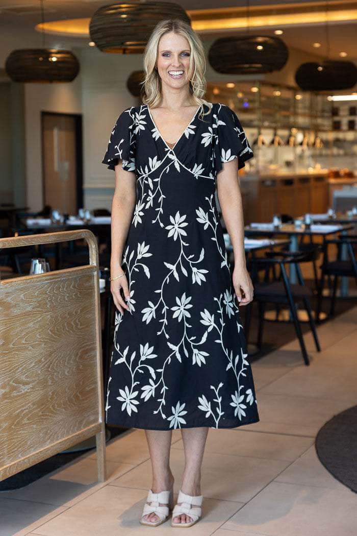 black midi dress with a white floral embroidery vine pattern