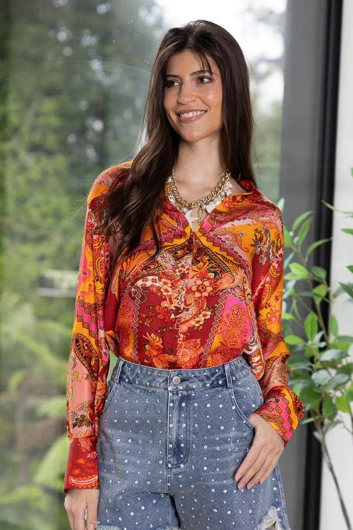 vibrant, long-sleeved button-up blouse with a red, orange, and yellow paisley pattern