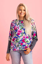 A blue floral print top with a navy back striped ribbing