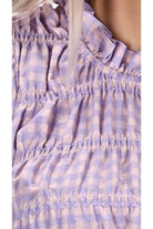 A lilac gingham print top with shirred seams